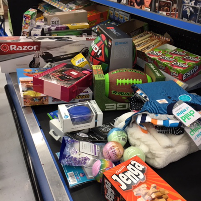 Pile of toys and unwrapped gifts at checkout area of department store