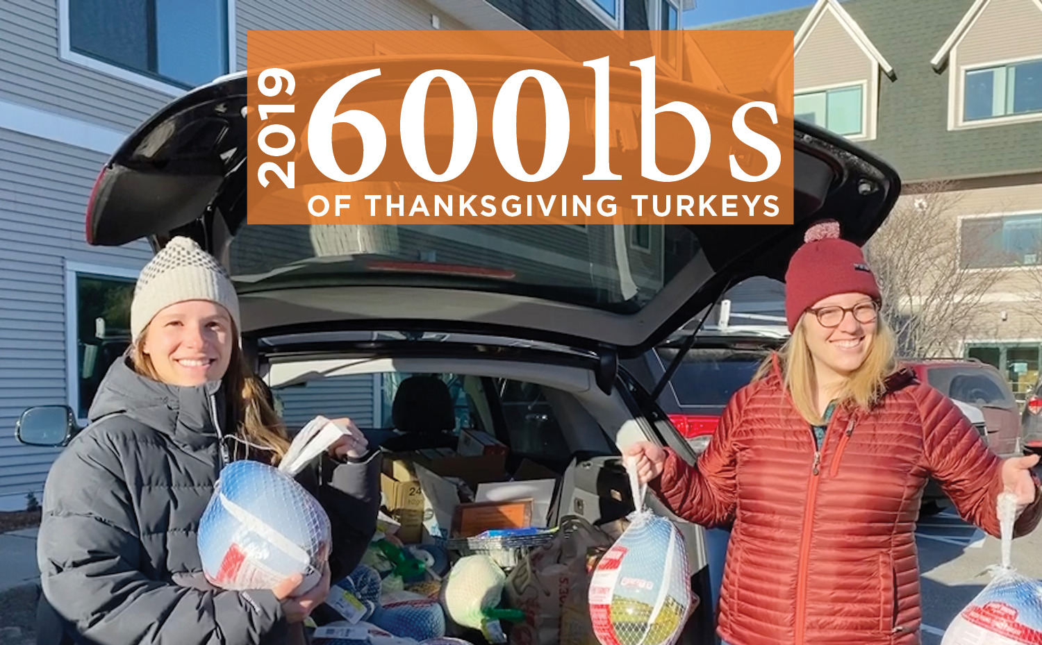 Two smiling women from the E4H Vermont team loading a car and holding turkeys to donate to the local food bank