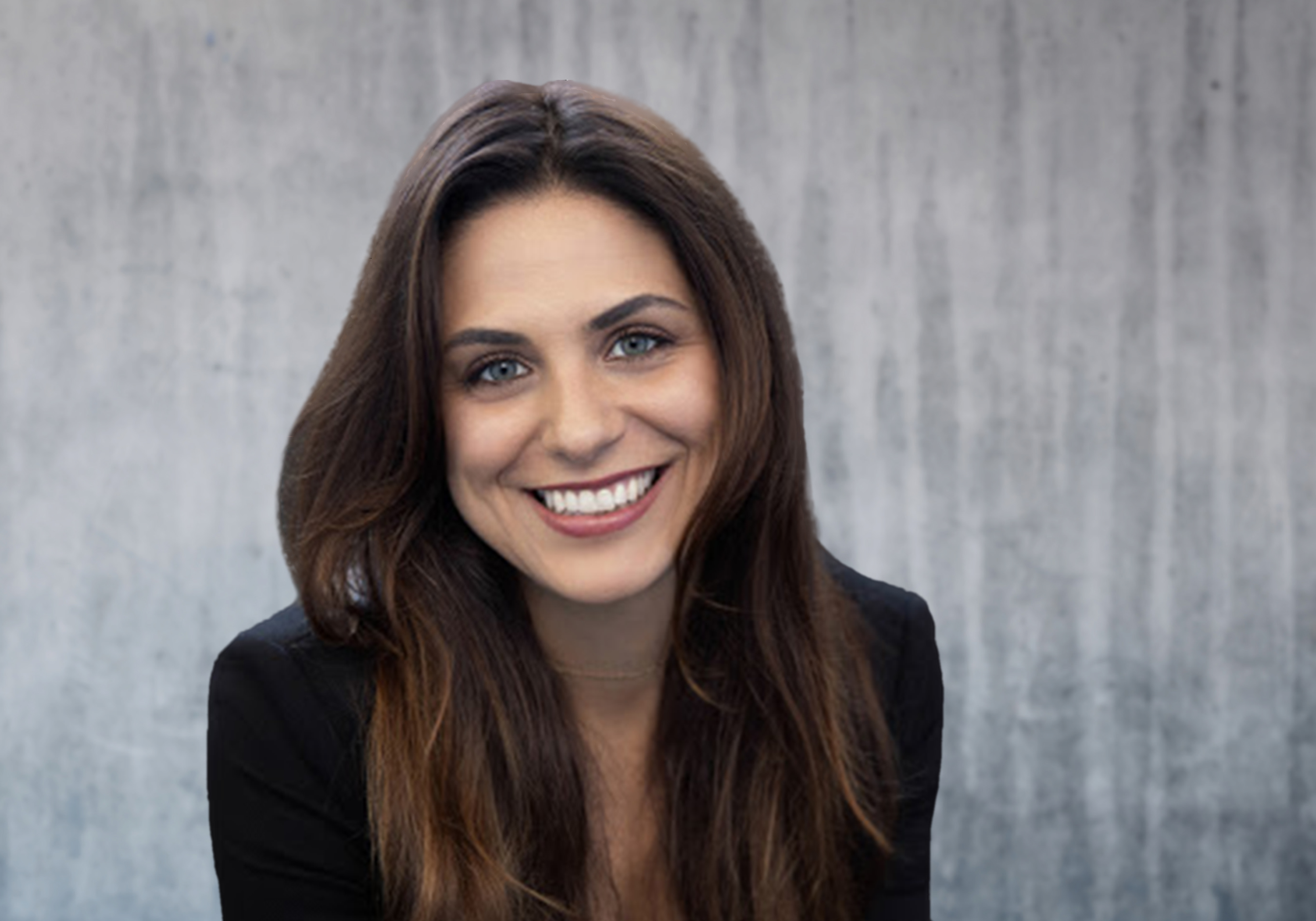 A woman, Anne Marie Garcia, smiling broadly while wearing a blazer