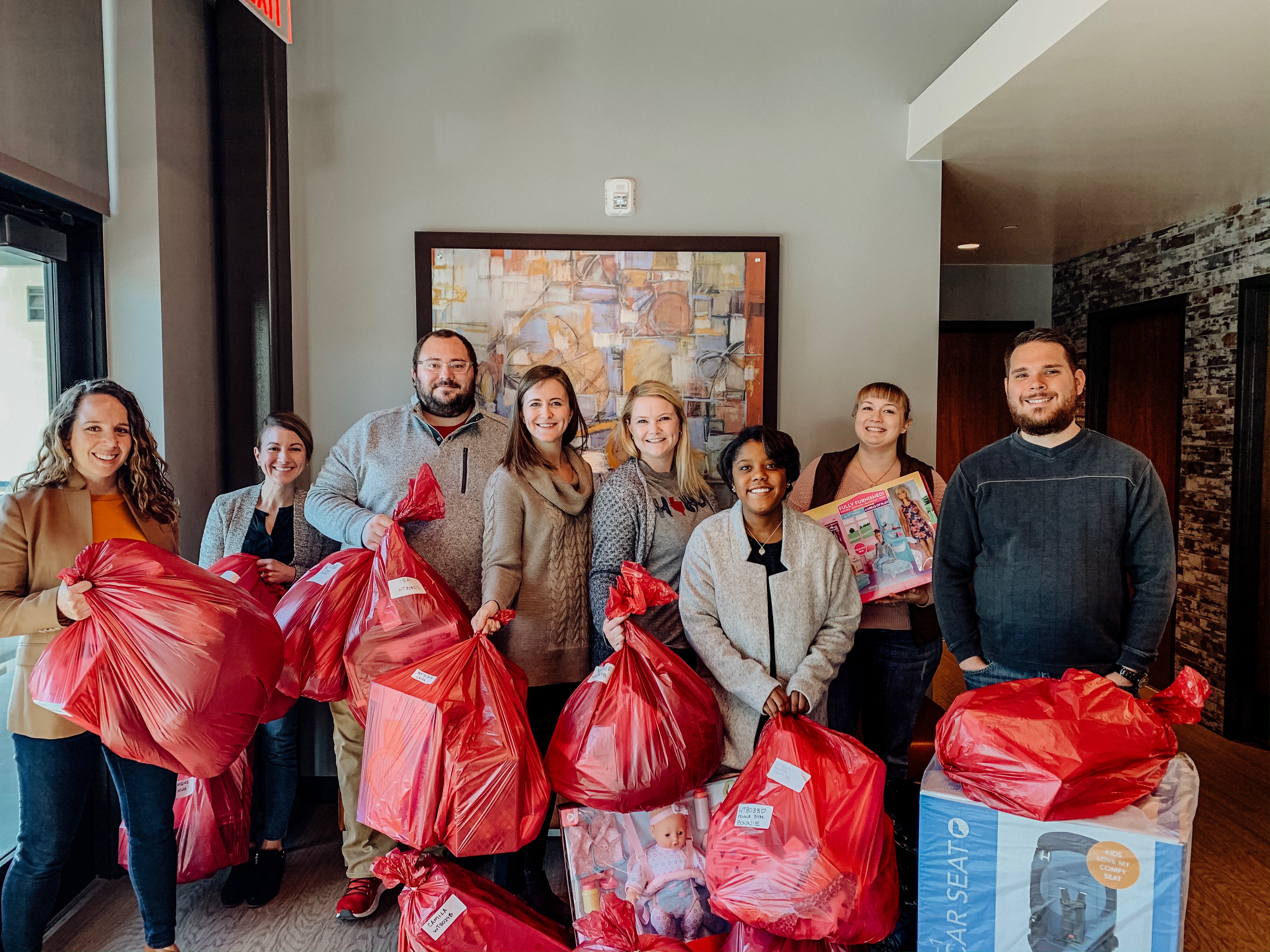 The E4H Fort Worth team with red gift bags for the E4HCares 2019 Donation to Salvation Army