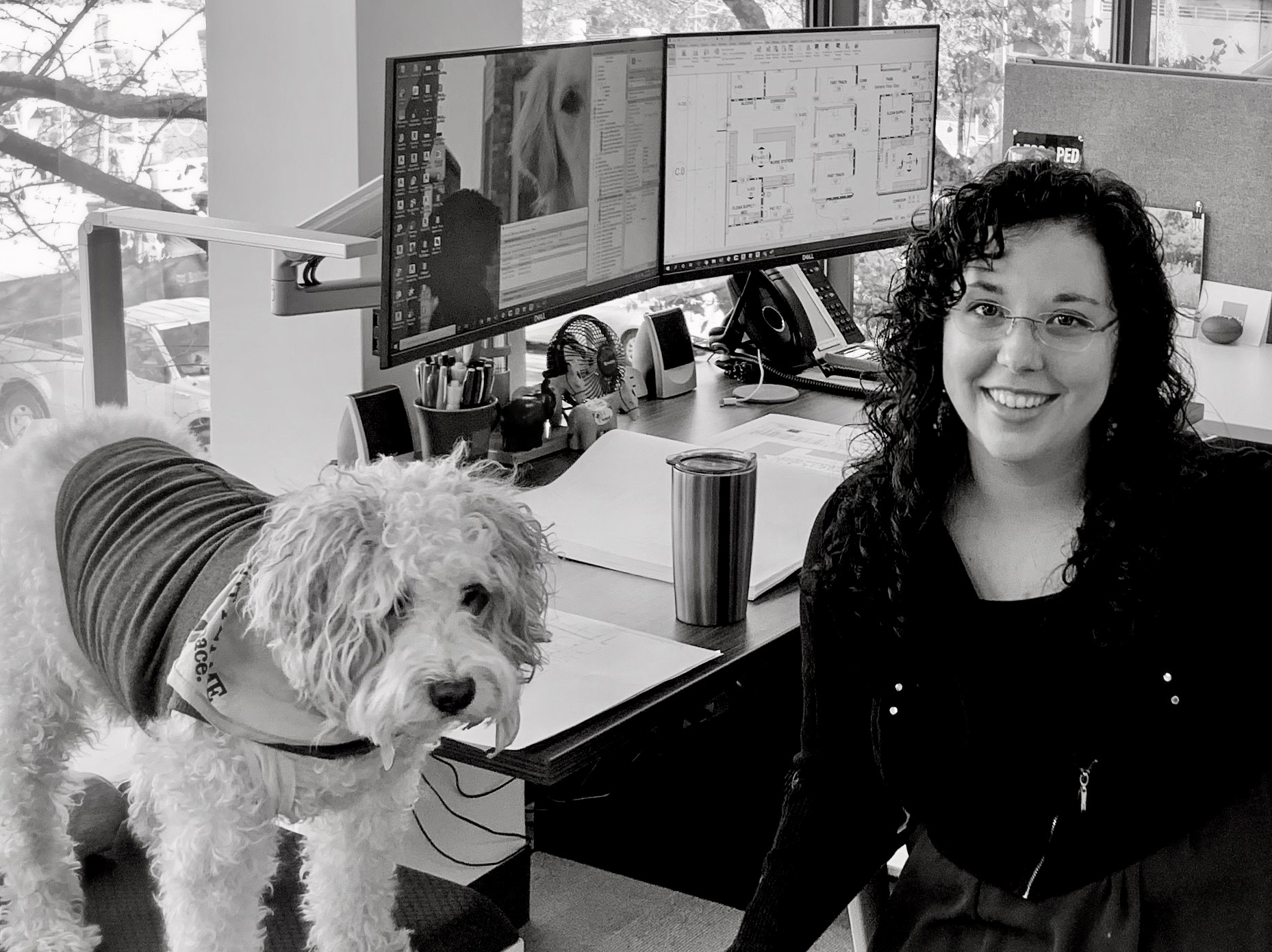 Katie Fligg, Healthcare Designer at her desk with her dog in Nashville